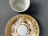 a cup and saucer sitting on a table next to each other
