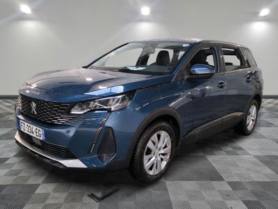 une voiture bleue est garée dans une pièce au sol à carreaux
