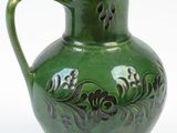 a green vase that is sitting on a white surface