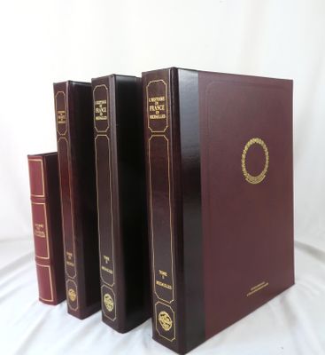 four books are lined up in a row on a white surface