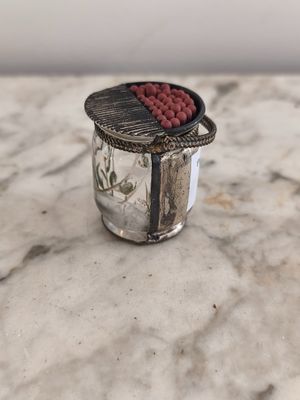 un bocal en verre contenant une perle rouge