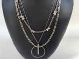 a black mannequin with a cross and other jewelry on it