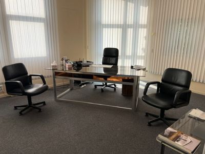 une photo d'un bureau vide avec un bureau et des chaises