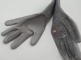 pair of gray gloves on a white surface with a blue string