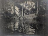 une photo en noir et blanc d'une maison au bord de l'eau