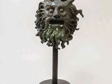 a statue of a green man with a beard on a stand