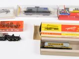 beaucoup de trains miniatures dans une boîte sur une table
