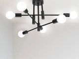 un lustre noir avec des ampoules blanches suspendu au plafond