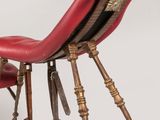 a red chair that is sitting on a metal stand