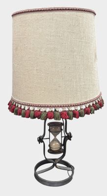a lamp that is sitting on a stand with a lamp shade on it