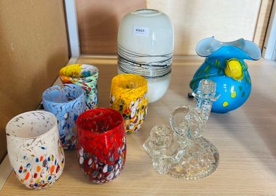 many different colored cups and vases sitting on a table