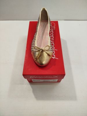 quelqu'un porte une paire de chaussures qui se trouvent sur une boîte rouge