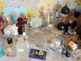 de nombreux flacons de parfum posés sur une table devant un mur