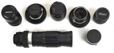 many different types of cameras and lenses on a white surface