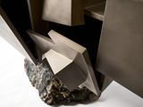 a sculpture made out of metal and rocks on a white surface
