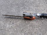 an image of a chainsaw and a drill on the ground