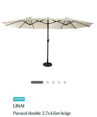 un parapluie blanc posé sur une table près d'un mur blanc