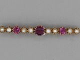 a close up of a purple and white bracelet with pearls