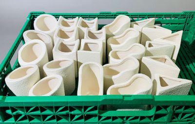 une caisse en plastique verte remplie de tasses et de bols blancs