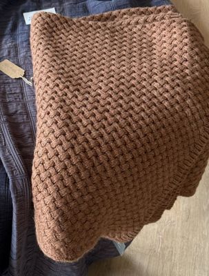 une couverture tricotée marron posée sur une chaise