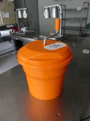 un seau orange posé sur une table dans une cuisine