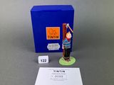 a figurine of a man holding a baseball bat in front of a blue box