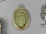 three pieces of jewelry including a silver broochee, a silver spoon, and a silver broochee