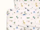 an image of a bed with a white sheet with a pattern of animals on it