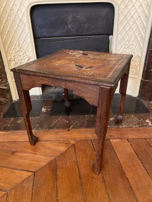 une petite table avec un plateau en bois posée sur un parquet en bois dur