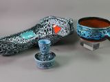 two cups and a bowl sitting next to each other on a table
