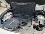 the back of a car with the hood open and a bag in the trunk