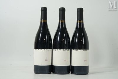 three bottles of wine are lined up on a white surface