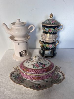 une table blanche sur laquelle se trouvent une théière et une autre théière