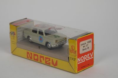 une petite voiture miniature dans une boîte posée sur une surface blanche