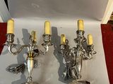 three silver candelabs with yellow candles on a table