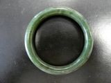 un bracelet vert posé sur une table noire