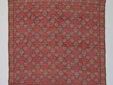 an orange and brown rug with fringes hanging on a wall