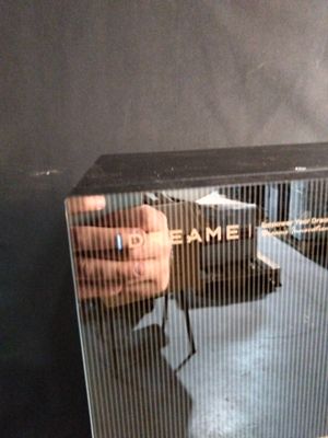 un flacon de parfum posé sur une table, tenu par une personne