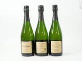 trois bouteilles de vin posées les unes à côté des autres sur une surface blanche