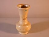 un vase blanc bordé d'or posé sur une table