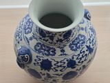 a blue and white vase sitting on a wooden table