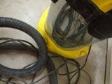 a vacuum that is sitting on the floor next to a hose