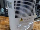 a white air conditioner sitting on a wooden table