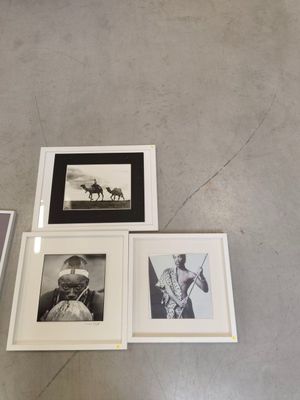 Plusieurs photographies en noir et blanc sont exposées à même le sol