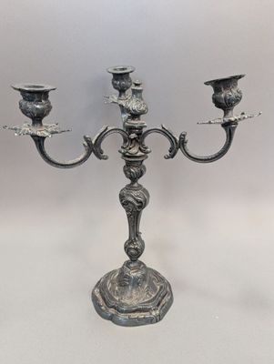 une image représentant un candélabre en argent surmonté de trois bougies