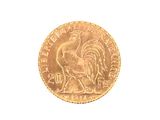 a gold coin with a rooster on it on a white surface