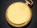a gold pocket watch on a black surface