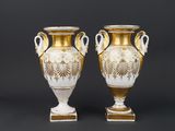 pair of antique vases with gold and white designs on them