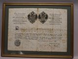 an old document is hanging on a wall next to a framed picture