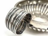 a silver ring that is sitting on top of a silver bowl